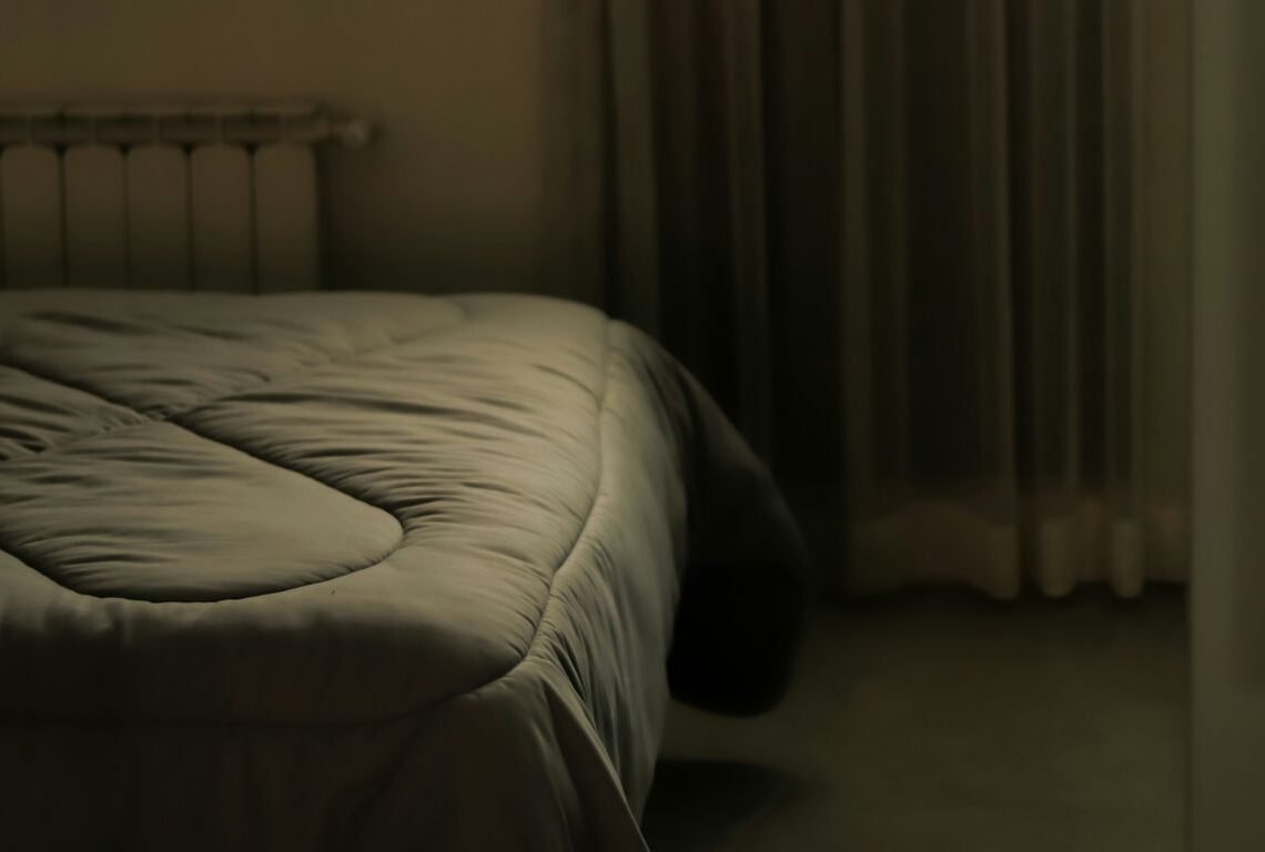 A blurry image of a bed in a bedroom