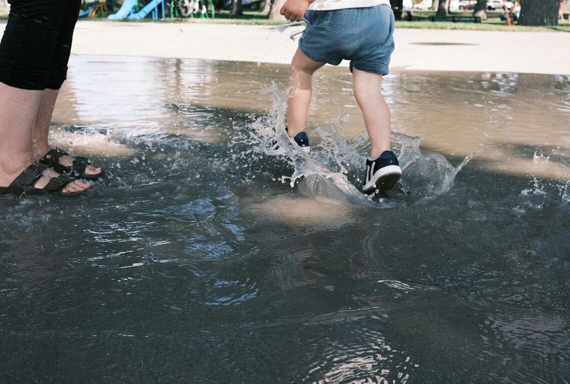 woman in white shirt and blue denim shorts standing on water during daytime